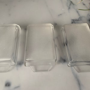 K&ouml;nnte beinhalten: Drei rechteckige Glasschalen aus klarem Glas mit mattem Boden. Die Schalen sind leer und haben einen leichten Rand.