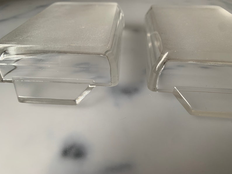 K&ouml;nnte beinhalten: Zwei rechteckige Beh&auml;lter aus klarem Kunststoff mit einem erh&ouml;hten Rand oben und einem Rand unten. Die Beh&auml;lter sind leer und scheinen aus einem strapazierf&auml;higen Material zu bestehen.