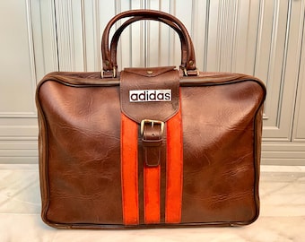 RÉSERVÉ AUX COLLECTIONNEURS ! Sacoche de voyage vintage Adidas années 70 en cuir, très rare, neuve de stock, fabriquée en France par MFS. Photo publicitaire.