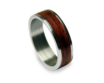 May include: A silver ring with a brown wood inlay. The ring is a simple design with a smooth finish.