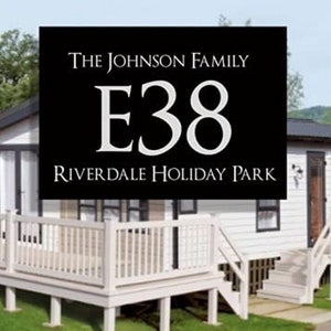 May include: A white wooden cabin with a black sign that reads "The Johnson Family E38 Riverdale Holiday Park".