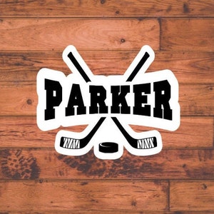 May include: A white sticker with a black hockey stick design and the name "PARKER" in black text.