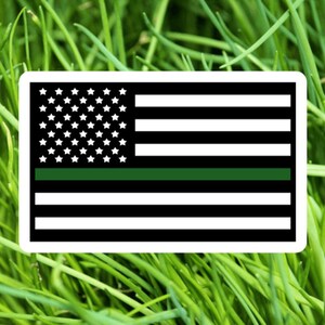 May include: A thin green line is added to the American flag, representing support for law enforcement.