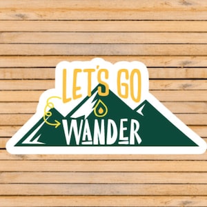 May include: White sticker with a green mountain range and yellow text that reads "Let's Go Wander".