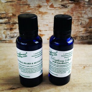 May include: Two blue glass bottles of beard and mustache oil with black caps. One label reads "Natural Beard & Mustache Oil" and the other reads "Raspberry Sweet." The labels also include the brand name and website.