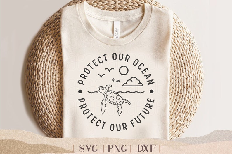 May include: Cream-colored t-shirt with a circular graphic that reads "Protect Our Ocean, Protect Our Future." The design features a sea turtle, sun, clouds, birds, and waves. The shirt is displayed on a woven basket.