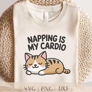 Könnte beinhalten: Ein weißes T-Shirt mit dem Text "Napping is my cardio" und einer Cartoon-Illustration einer schlafenden braunen und weißen Katze.