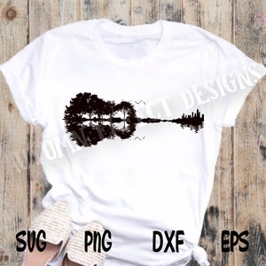 May include: A white t-shirt featuring a black silhouette of a guitar with trees reflected in the water. The guitar is formed by the reflection of the trees in the water.