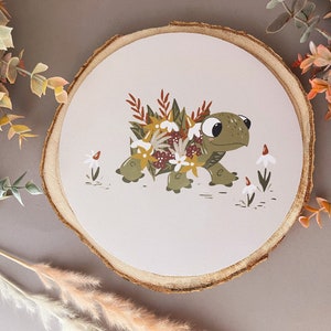 May include: A green turtle with a shell covered in flowers and leaves. The turtle is walking on a white background with small white flowers.