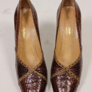 K&ouml;nnte beinhalten: Ein Paar braune Lederschuhe mit Schlangenhautmuster und braunen N&auml;hten. Die Schuhe sind von der Marke "Melluso" und wurden in Italien hergestellt.