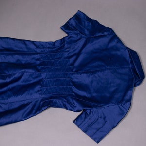 May include: A navy blue short-sleeved jacket with a collar and a fitted waist.