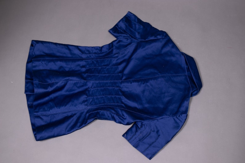 May include: A navy blue short-sleeved jacket with a collar and a fitted waist.