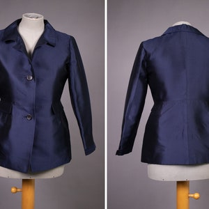 May include: A navy blue blazer with a classic collar, two button closure, and long sleeves. The blazer has a fitted silhouette and a slightly flared hem.