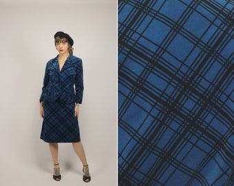 May include: A blue and black plaid skirt suit with a fitted jacket and a-line skirt. The suit is made of a soft, velvety fabric.
