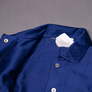 May include: A navy blue jacket with a white label and silver buttons.