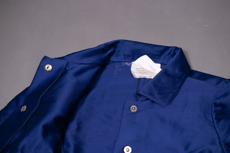 May include: A navy blue jacket with a white label and silver buttons.