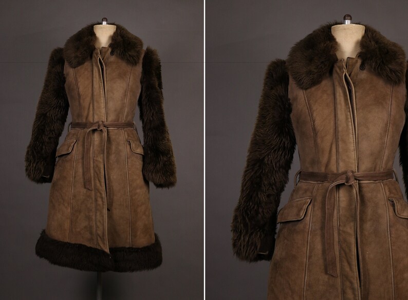 May include: A brown leather coat with a fur collar and cuffs. The coat has a belt and two pockets.