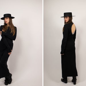 May include: A black long-sleeved dress with a keyhole back detail and a black wide-brimmed hat.