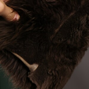 May include: Close-up of a brown faux fur fabric. The fur is soft and fluffy, with a slight sheen.