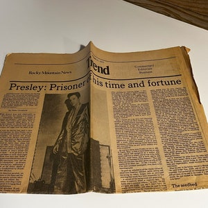May include: A black and white newspaper clipping with the headline "Presley: Prisoner of his time and fortune". The article discusses Elvis Presley's life and career. A photo of Elvis Presley in a black suit and white shirt is featured in the clipping.
