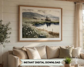 Puede incluir: Una impresión enmarcada de un paisaje en acuarela que presenta una serena escena de lago con colinas y una valla de madera. La obra de arte está en un marco de madera clara y cuelga sobre un sofá beige. El texto "INSTANT DIGITAL DOWNLOAD" se muestra en la parte inferior.