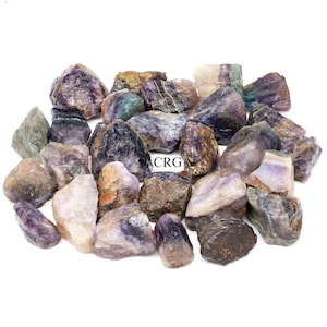 May include: A collection of purple, green, and brown fluorite crystals. The crystals are rough and have a variety of shapes and sizes.