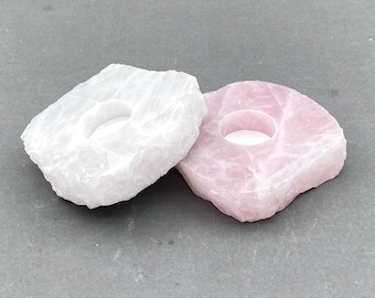 Könnte beinhalten: Zwei Kerzenhalter aus Naturstein, einer weiß und einer rosa, mit einer runden Vertiefung in der Mitte für ein Teelicht.