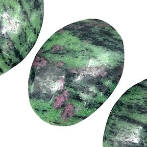 May include: Three smooth, oval-shaped green stones with black and pink marbling. The stones are polished and have a natural, earthy look.