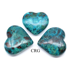 May include: Three heart-shaped stones with a teal and brown mottled pattern. The stones are polished and smooth, with a glossy finish. The text "CRG" is printed in black on the bottom right of the image. These stones are likely used for decorative purposes.