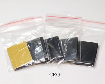 May include: Four small, black adhesive pads in individual clear plastic bags with a gold adhesive pad in one bag. The bags have red zipper closures. The text "CRG" is printed below the bags.