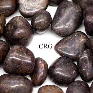 May include: A collection of polished, dark purple stones with a smooth, rounded shape. The stones have a glossy finish and varying shades of purple and brown. The text "CRG" is visible in white. These stones are ideal for crystal healing or decorative purposes.