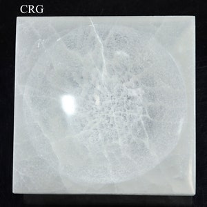 May include: A white, square, selenite charging plate with a round, recessed center. The plate has a natural, cloudy, and translucent appearance.