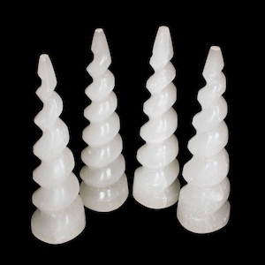 Puede incluir: Cuatro cuernos de unicornio de cristal de selenita blanca. Los cuernos son en espiral y tienen un acabado liso y pulido.