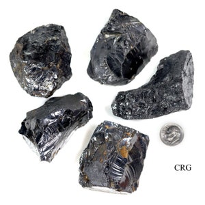 May include: Five black obsidian stones of varying sizes and shapes, with a US quarter for scale. The stones have a shiny, glassy surface.
