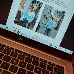 May include: A laptop screen displays a knitting pattern for a cloud cardigan. The pattern, designed by Moni Knitting, features a light blue cardigan. The text describes the garment as light, airy, and comfortable, highlighting the beauty of mohair yarn.