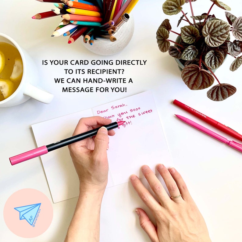 May include: A white card with a handwritten message that reads "Dear Sarah, Thank you sooo for the sweet gift!" The card is on a white surface with a pink pen and a red pen.