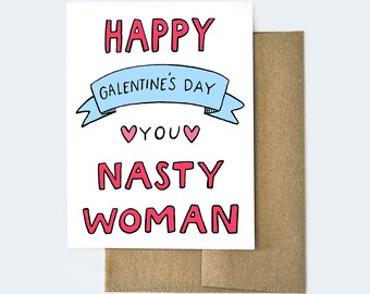 May include: A white card with a blue and pink design. The card says "Happy Galentine's Day You Nasty Woman".