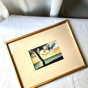 May include: A framed watercolour painting of a sunset over a body of water with a silhouette of a tree in the foreground.