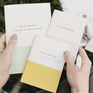May include: Three small notebooks with different coloured covers and handwritten text. The text on the notebooks reads "Garrulous Gabbie's repository of arcane information", "Oh my giddy kipper!!", and "All the reasons why I love you".