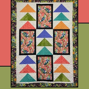 May include: A quilt pattern called "Peking Duck" by Heidi Cook for Villa Rosa Designs. The quilt features a patchwork design with a variety of colorful triangles and squares. The center of the quilt features a repeating pattern of owls on branches.