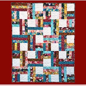May include: A quilt pattern called "Genoa" by Rachelle Handmade for Villa Rosa Designs. The quilt is made of colorful fabric scraps in shades of blue, red, brown, and yellow. The pattern is a grid of squares with strips of fabric running horizontally and vertically.
