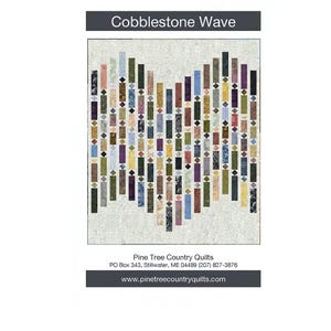 May include: A quilt pattern named "Cobblestone Wave" with a design of vertical rectangular blocks in various colours, including blue, green, and brown. The pattern is from Pine Tree Country Quilts, with their website address at the bottom.