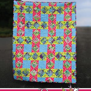 May include: A quilt featuring a grid pattern of light blue, lime green, and hot pink fabric squares with multi-colored floral and abstract prints. The text 'Loomed' appears at the top, and 'Running Doe QUILTS For Villa Rosa Designs' at the bottom.