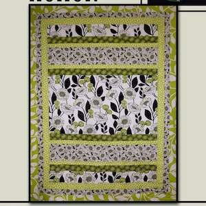 May include: A quilt pattern called "Honor" by Villa Rosa Designs. The quilt features a black and white floral print with green accents. The quilt is surrounded by a green border with a leaf pattern.