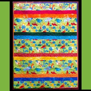 May include: A colorful quilt with the text "Simple Simon" at the top. The quilt features various patterned fabrics in green, orange, red, and blue. The quilt is made by Tricia Lynn Maloney of Orphan Quilt Designs.