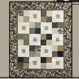 May include: A patchwork quilt with a geometric design in neutral tones. The quilt features squares in white, grey, and black, with patterned and solid blocks. The border has a floral print. The word "POLO" is at the top. "Villa Rosa Designs" is at the bottom.