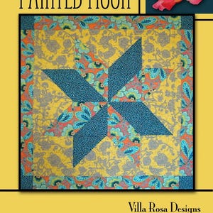 Peut inclure: Une courtepointe colorée avec un motif d'éclat d'étoile. La courtepointe présente une étoile centrale dans des tons de bleu, entourée d'un fond jaune avec des motifs floraux orange, gris et sarcelle. Le texte "PAINTED MOON" est en haut.