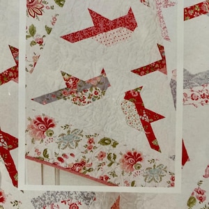 May include: A white background features a quilt pattern with red cardinal bird designs. The birds are made of patterned fabric with floral and polka dot prints. The text "Cardinals" is at the bottom.
