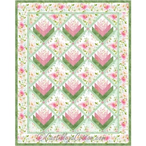 Puede incluir: Un patrón de colcha con un fondo de estampado floral y un diseño de triángulos rosas y verdes que forman una forma de flor. La colcha está rodeada por un borde verde con un estampado floral.