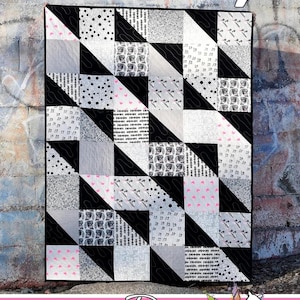 May include: A black and white quilt with a geometric pattern. The quilt is called "Waverly" and is made by Running Doe Quilts for Villa Rosa Designs.